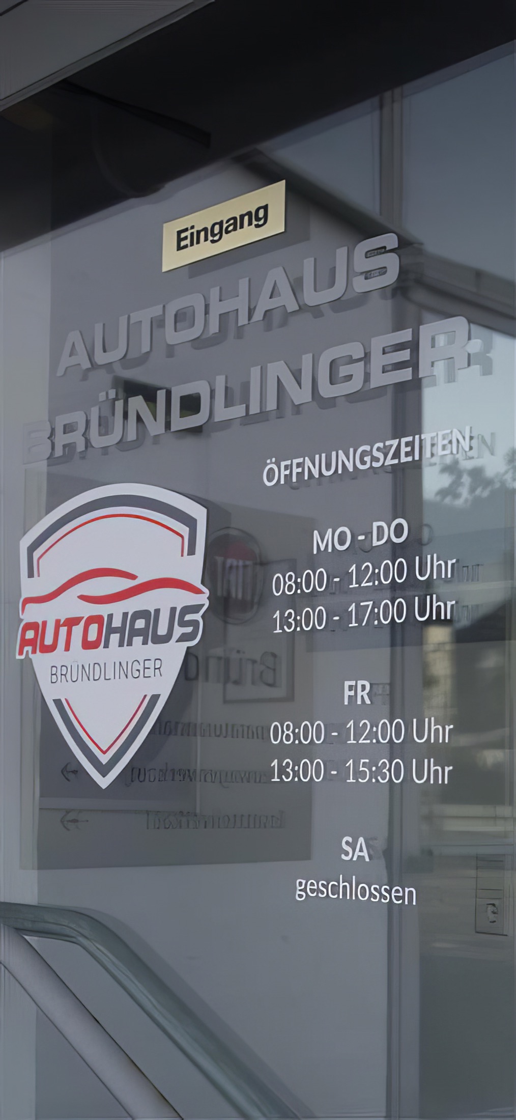 Eingangsbereich des Autohauses Bründlinger mit Beschriftung